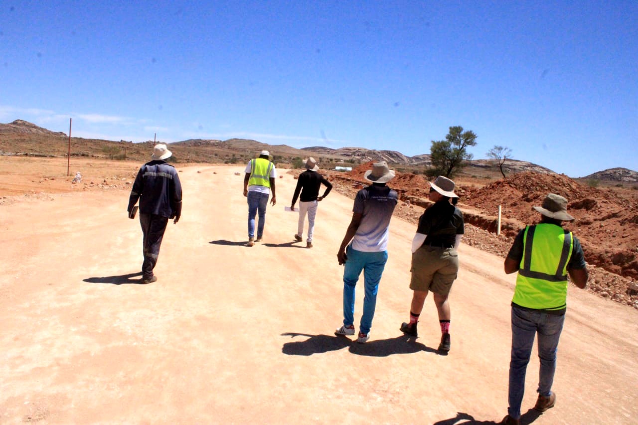 Engineers walking a road formation at Aus