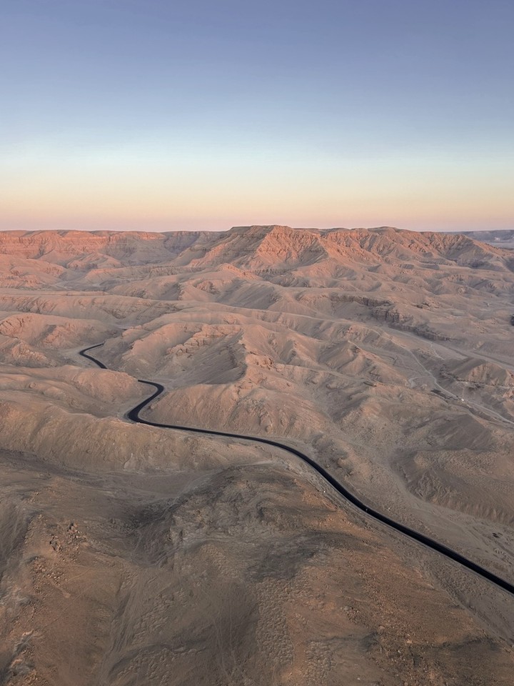 Surfaced road crossing arid high ground, seen from the air